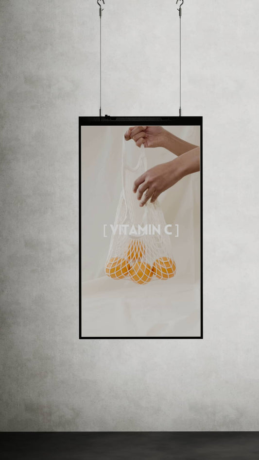 Opvallend 55-inch verticaal digital signage scherm aan kabels met ingebouwde Android-player en cloud-gebaseerde software, in een hoogte verstelbaar frame geschikt voor plafondmontage.